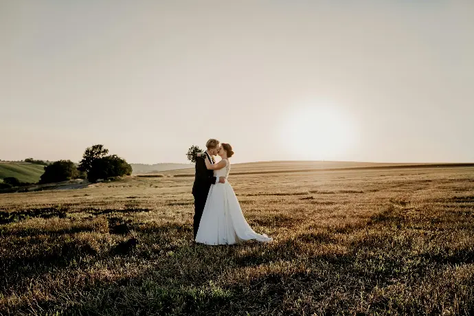 woman in white dress standing on green grass field during daytime